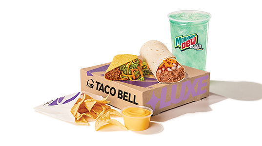 A beef and cheese burrito, a beef taco, corn tortilla chips with cheese sauce, and a Baja Blast.