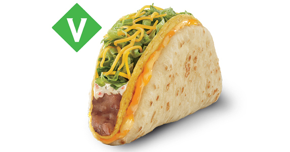 A hard shell taco filled with refried beans, sour cream, lettuce, and cheese. There is a tortilla wrapped around the hard shell taco with a layer of cheese between the two.