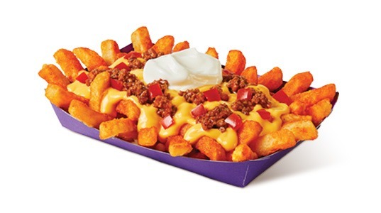 A bunch of fries with cheese sauce, ground beef, diced tomato, and sour cream on top.