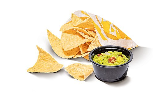 A bag of corn tortilla chips with a half-full cup of guacamole.
