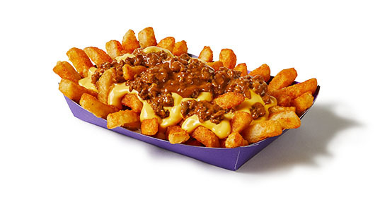 A bunch of fries with cheese sauce, ground beef, and chili sauce on top.