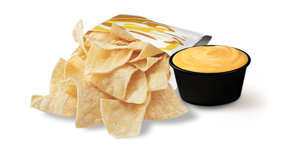 A bag of corn tortilla chips with a cup of cheese sauce.