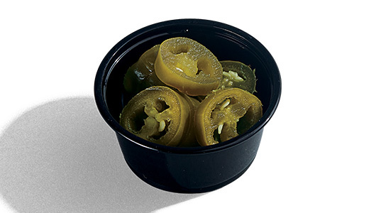 A dipping sauce cup filled with sliced, pickled jalapeño peppers.