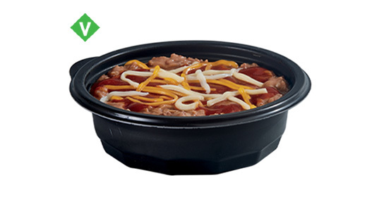 A small bowl of pinto beans with some cheese sprinkled on top.