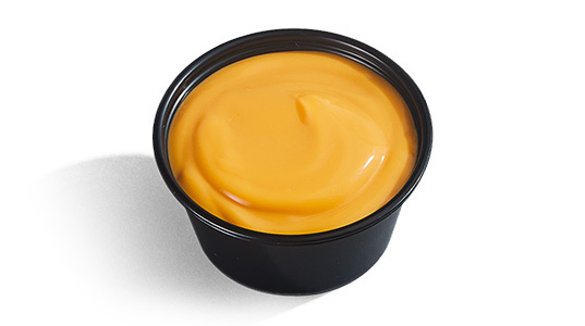 A dipping sauce cup filled with cheese sauce.