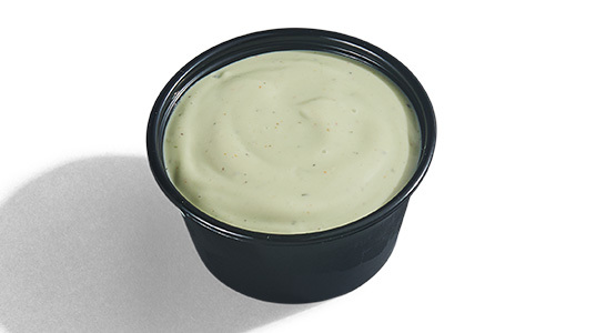 A dipping sauce cup filled with avocado ranch.